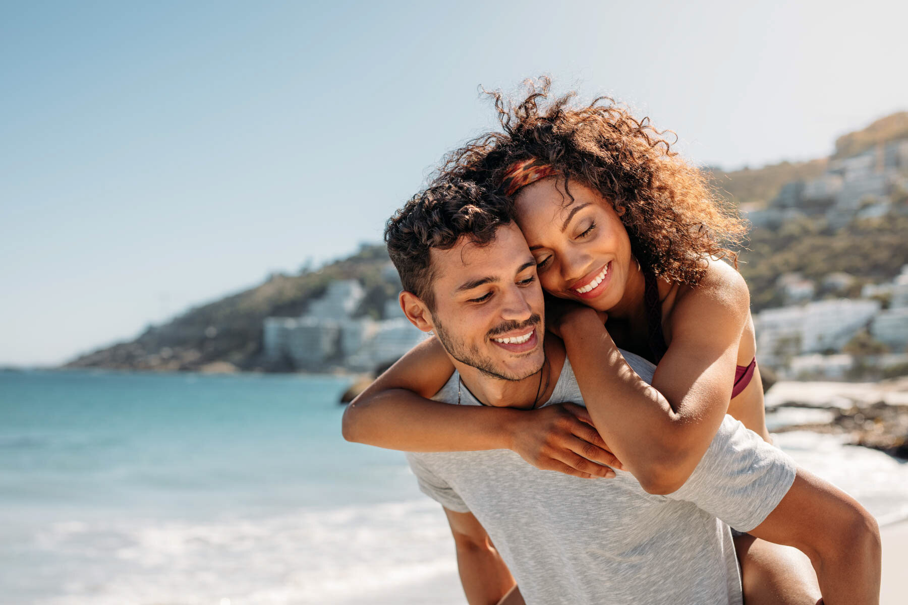 Joyful couple embracing on a sunlit beach